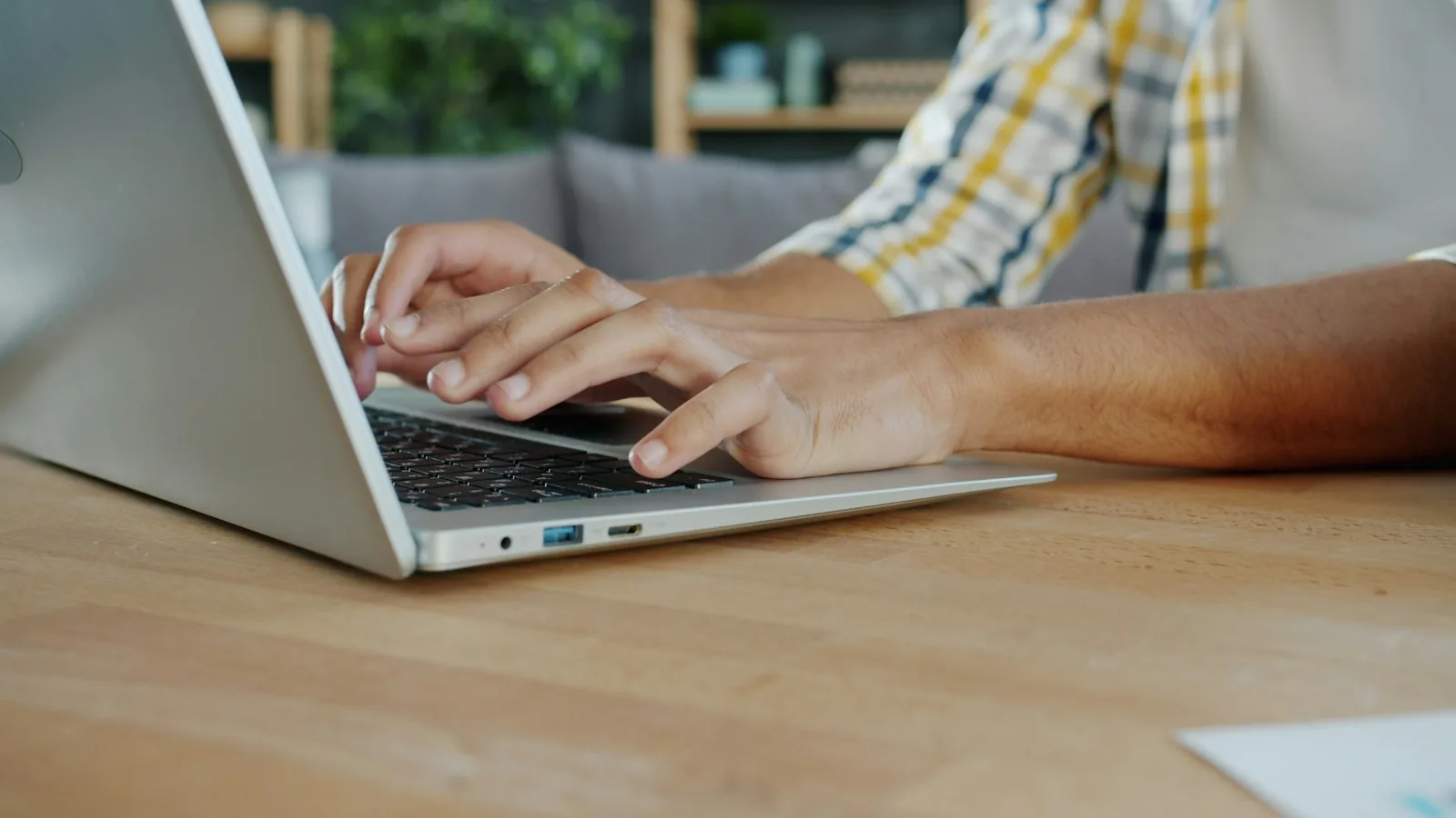 Hands typing on a laptop